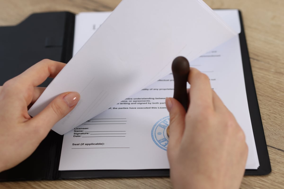 Person reviewing and stamping a document at a professional desk